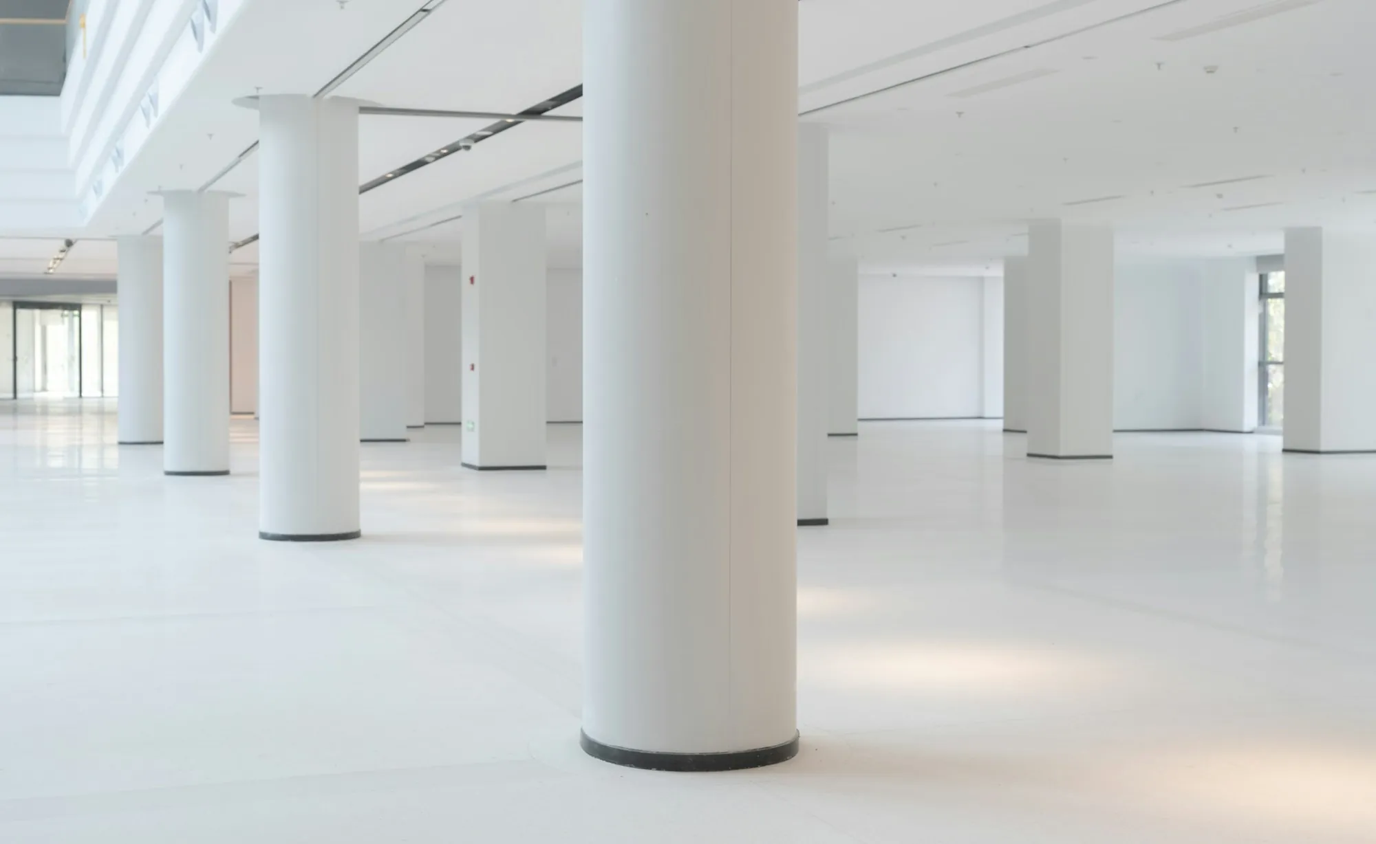 Empty white office space with columns and a shiny floor